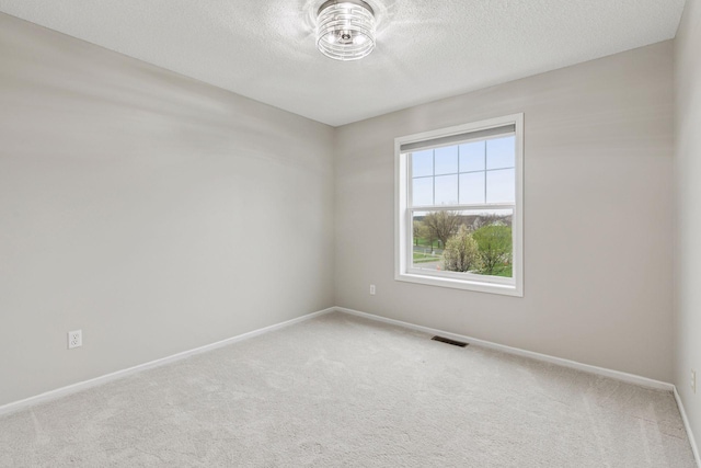 spare room featuring carpet floors, baseboards, and visible vents