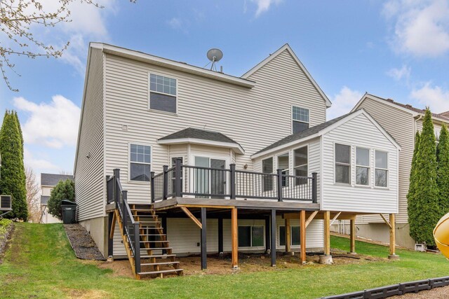 rear view of property with stairs, a wooden deck, and a yard