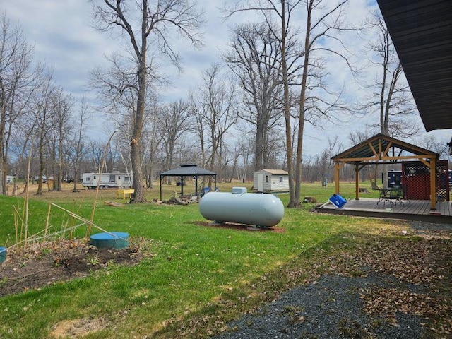 19675 Woody Ln NE, Kelliher, MN 56650 - view of yard featuring a storage unit, a gazebo, a deck, and an outbuilding