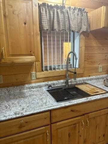 19675 Woody Ln NE, Kelliher, MN 56650 - details featuring light stone counters, wood walls, and a sink