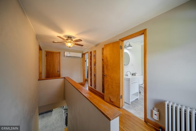 300 Carlson Rd, Cannon Falls, MN 55009 - corridor with light wood-style floors, a wall mounted air conditioner, radiator, an upstairs landing, and a sink