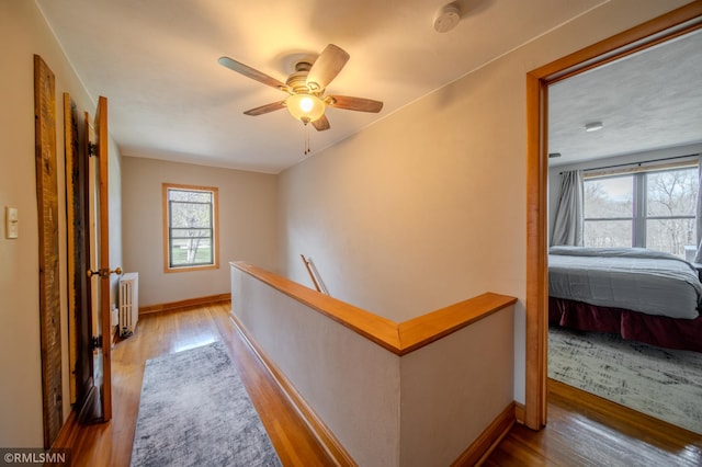 300 Carlson Rd, Cannon Falls, MN 55009 - corridor with radiator, an upstairs landing, wood finished floors, and baseboards