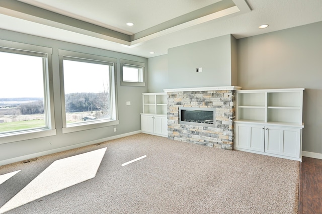 203 Walnut Hill Way, Troy Twp, WI 54022 - unfurnished living room featuring visible vents, a raised ceiling, baseboards, and a stone fireplace