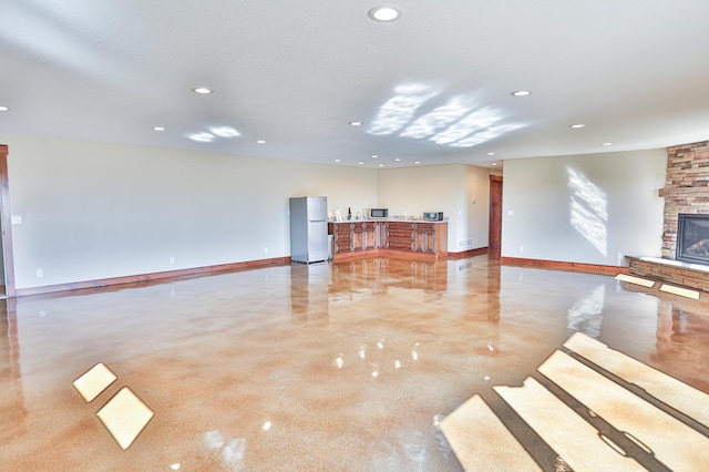 203 Walnut Hill Way, Troy Twp, WI 54022 - unfurnished living room featuring recessed lighting, baseboards, concrete flooring, and a stone fireplace