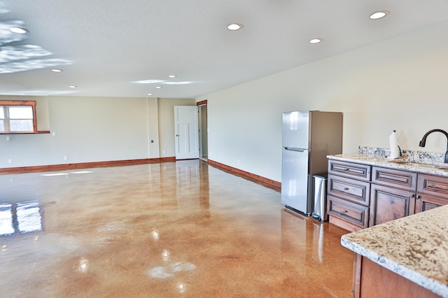 203 Walnut Hill Way, Troy Twp, WI 54022 - kitchen with concrete flooring, a sink, baseboards, freestanding refrigerator, and recessed lighting
