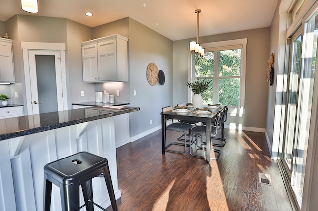 203 Walnut Hill Way, Troy Twp, WI 54022 - kitchen featuring dark wood finished floors, dark countertops, white cabinets, pendant lighting, and a kitchen breakfast bar
