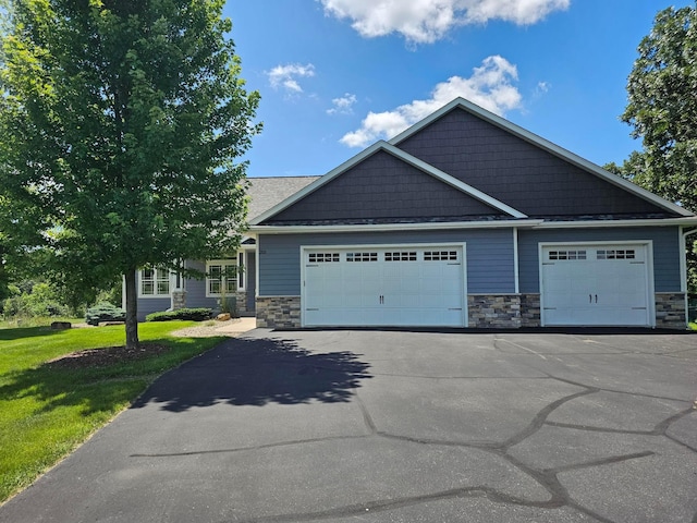 203 Walnut Hill Way, Troy Twp, WI 54022 - craftsman house featuring stone siding, asphalt driveway, an attached garage, and a front lawn