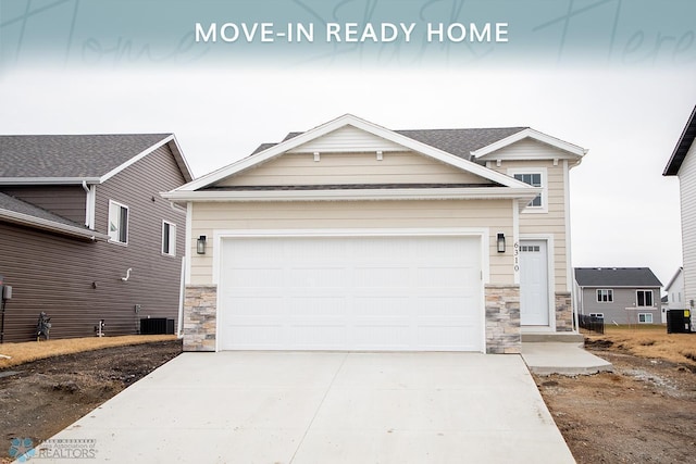 craftsman inspired home with central AC, stone siding, and concrete driveway