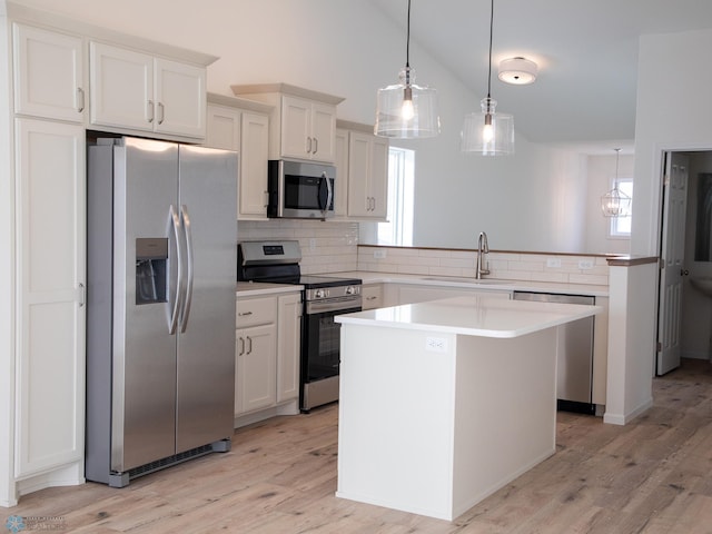kitchen featuring tasteful backsplash, a sink, light countertops, light wood-style flooring, and appliances with stainless steel finishes