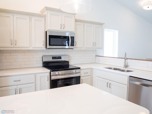kitchen featuring light countertops, white cabinets, appliances with stainless steel finishes, and a sink