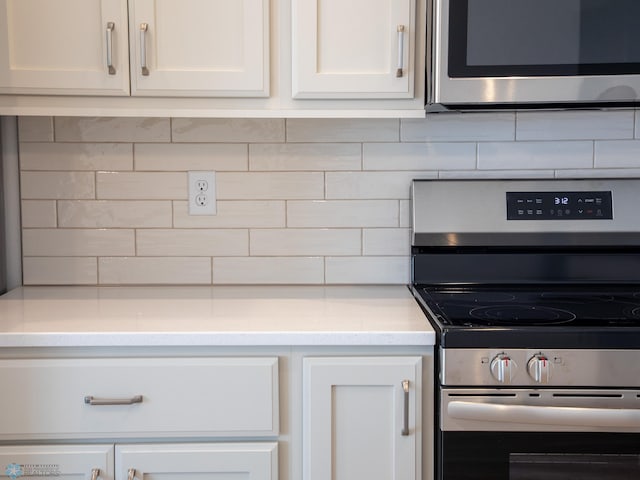 kitchen featuring white cabinetry, backsplash, and appliances with stainless steel finishes