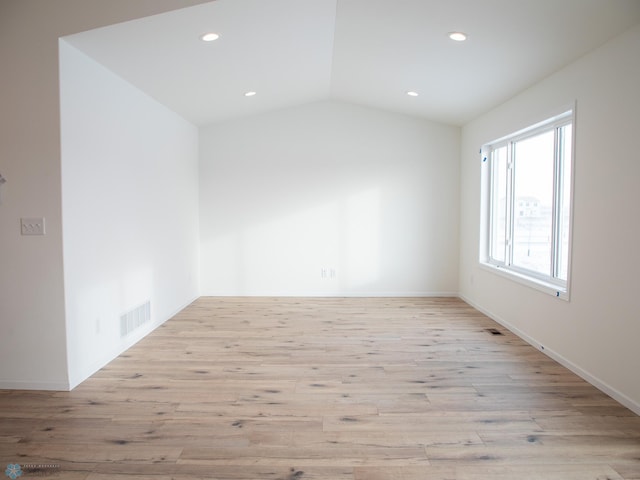 spare room featuring light wood-style flooring, visible vents, recessed lighting, and vaulted ceiling