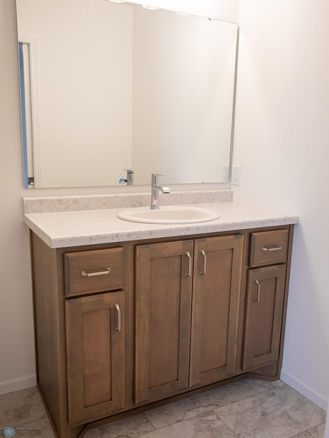 bathroom featuring baseboards, marble finish floor, and vanity