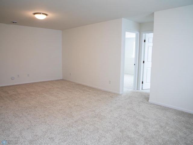 unfurnished room featuring carpet and baseboards
