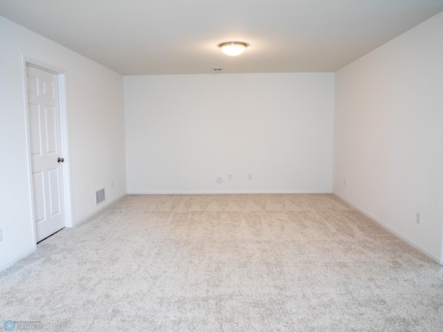 carpeted spare room with visible vents and baseboards