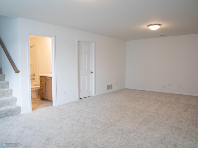unfurnished room featuring light colored carpet, baseboards, stairs, and visible vents