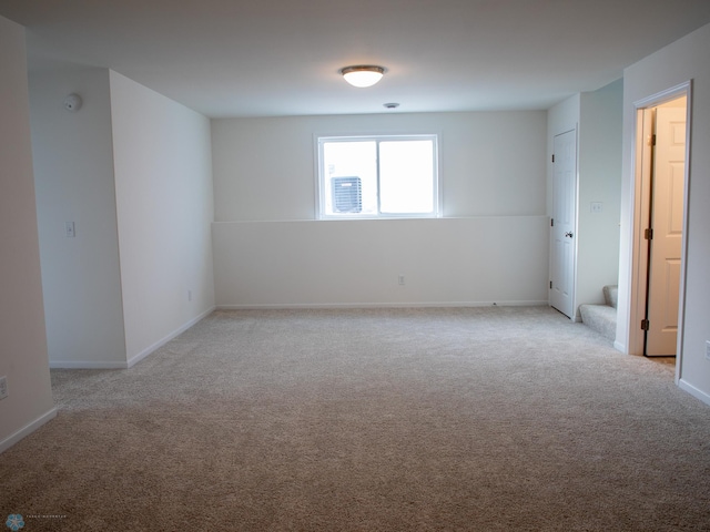 empty room with baseboards and light colored carpet