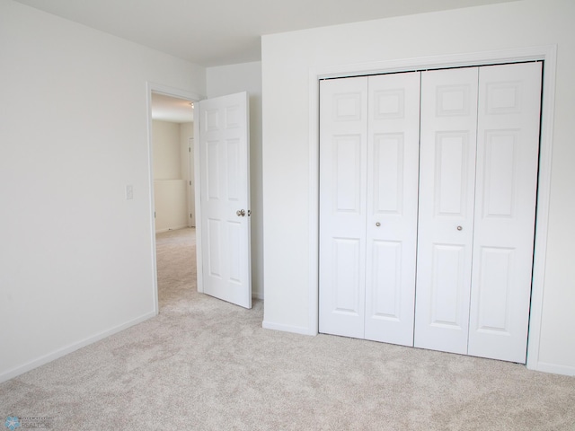 unfurnished bedroom featuring carpet, a closet, and baseboards