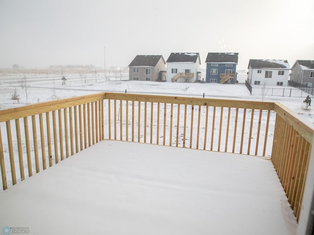snow covered deck with a residential view