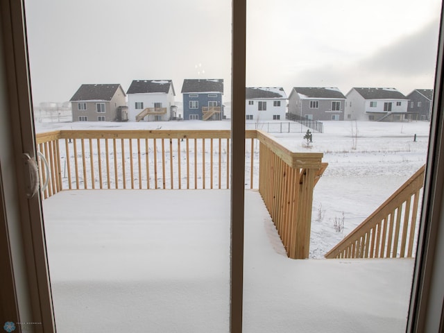 snow covered deck featuring a residential view
