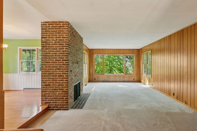 1433 Oldridge Ave N, West Lakeland Twp, MN 55082 - unfurnished living room with plenty of natural light, a brick fireplace, wooden walls, and carpet flooring