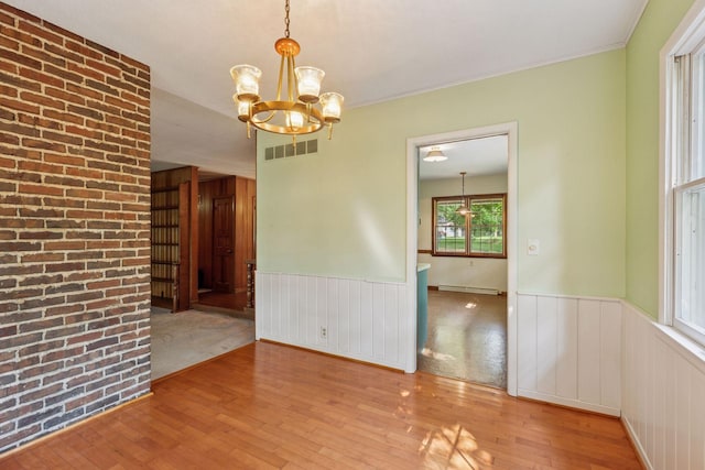 1433 Oldridge Ave N, West Lakeland Twp, MN 55082 - unfurnished dining area with a chandelier, wood-type flooring, a wainscoted wall, and baseboard heating