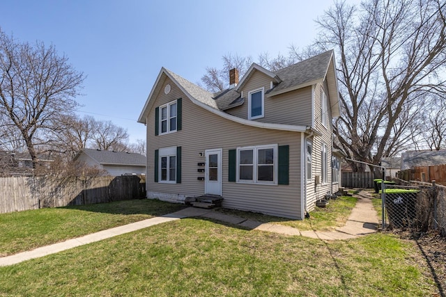 606 11th St SE, Rochester, MN 55904 - view of front facade with a chimney, a fenced backyard, entry steps, roof with shingles, and a front yard