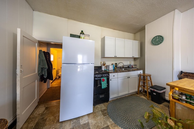 606 11th St SE, Rochester, MN 55904 - kitchen featuring freestanding refrigerator, dark countertops, a sink, white cabinetry, and black gas range
