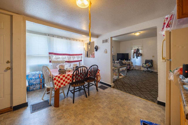 606 11th St SE, Rochester, MN 55904 - dining space with tile patterned floors, a textured ceiling, and visible vents