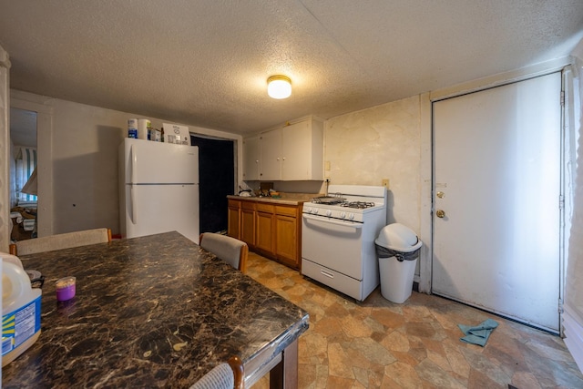 606 11th St SE, Rochester, MN 55904 - kitchen with a textured ceiling, white appliances, stone finish flooring, and brown cabinetry