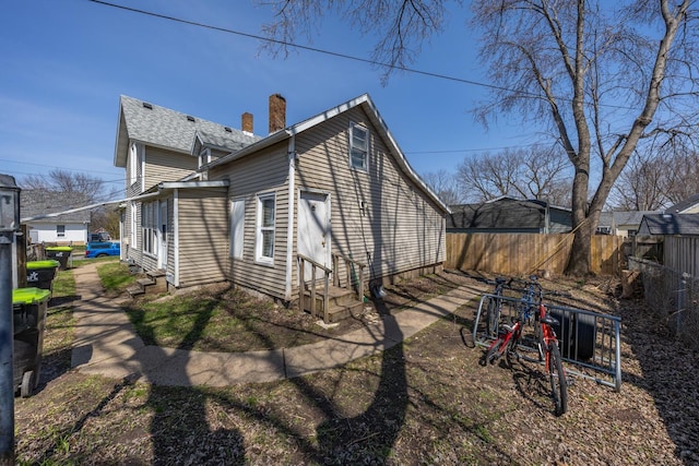 606 11th St SE, Rochester, MN 55904 - view of home's exterior featuring a chimney, entry steps, and fence