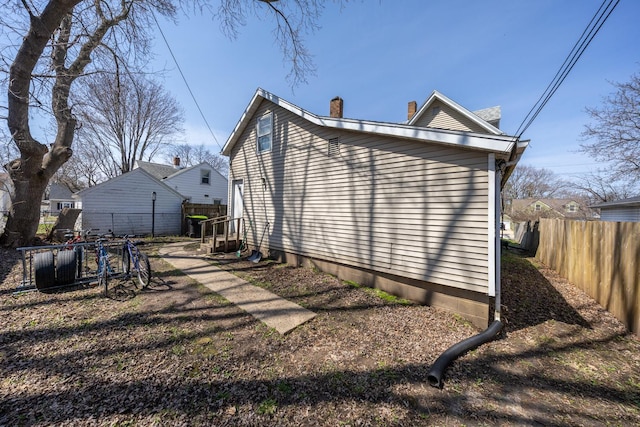 606 11th St SE, Rochester, MN 55904 - view of property exterior with a chimney and fence