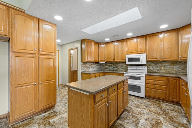 kitchen with white appliances, a kitchen island, backsplash, a textured ceiling, and a skylight