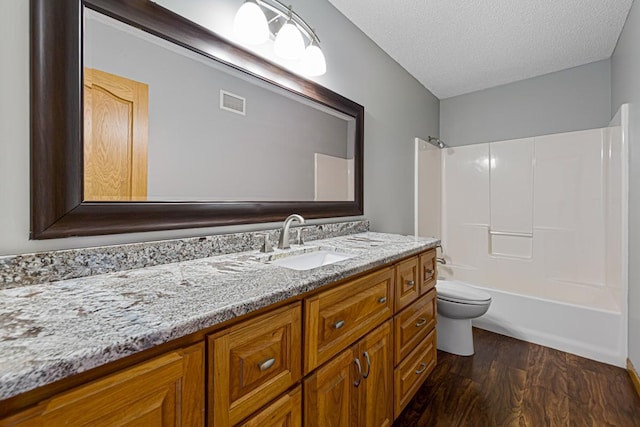 full bathroom with wood finished floors, toilet, shower / washtub combination, vanity, and visible vents