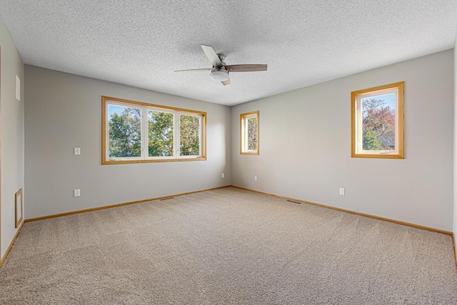 spare room featuring a textured ceiling, ceiling fan, baseboards, and carpet floors