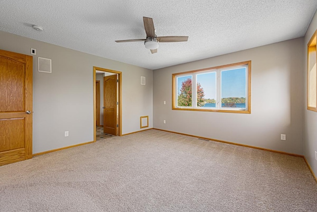 unfurnished bedroom featuring baseboards, light carpet, and a textured ceiling