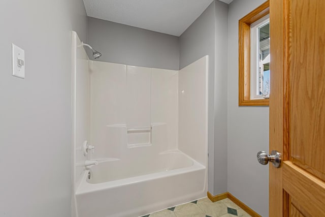 full bath with baseboards and tub / shower combination