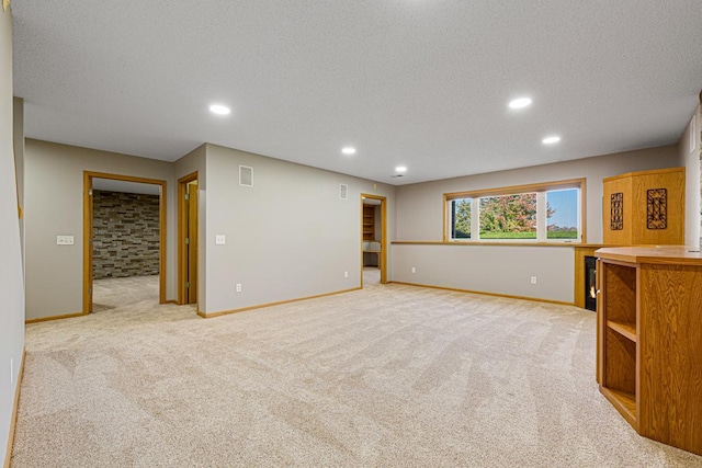 interior space with recessed lighting, light carpet, baseboards, visible vents, and a textured ceiling