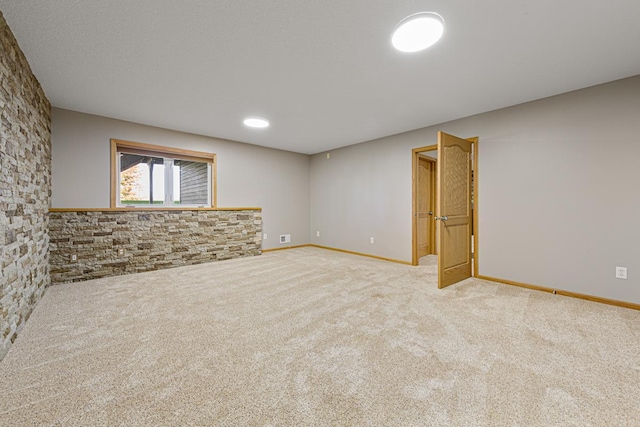 below grade area featuring carpet flooring, baseboards, and visible vents