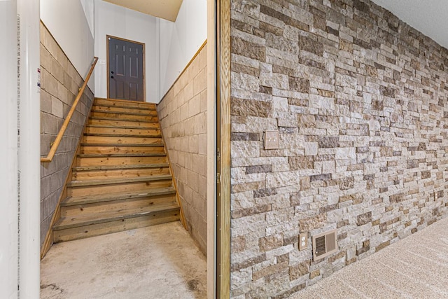 stairway featuring visible vents and concrete flooring