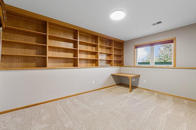 carpeted spare room featuring visible vents and baseboards