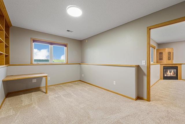 interior space featuring a textured ceiling, visible vents, and carpet