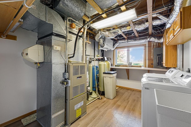 below grade area featuring light wood finished floors, washer and dryer, electric panel, and baseboards