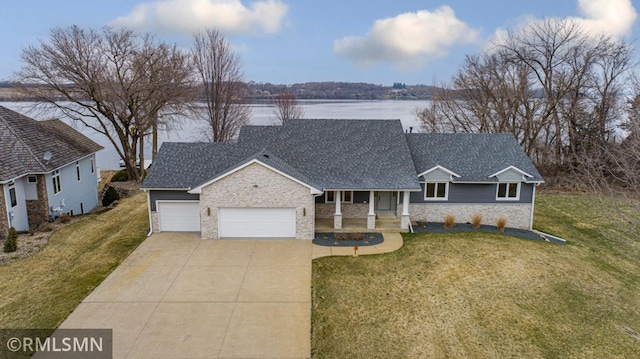 view of front of property featuring a front lawn, a shingled roof, stone siding, concrete driveway, and an attached garage