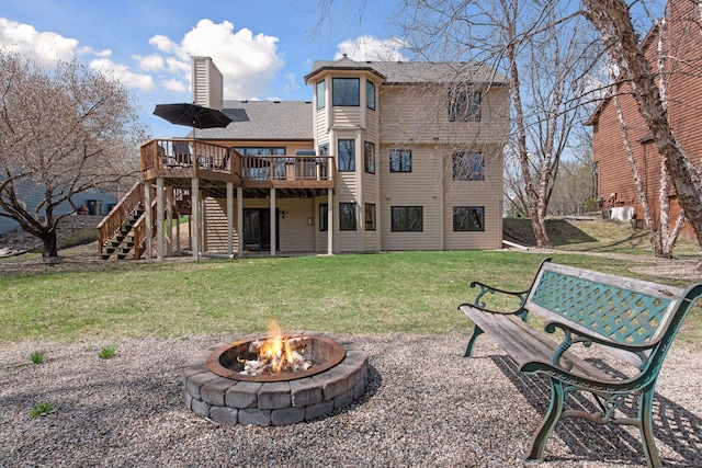 rear view of property featuring a wooden deck, stairway, an outdoor fire pit, a yard, and a chimney