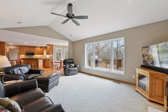 living area featuring light colored carpet, visible vents, a ceiling fan, and lofted ceiling
