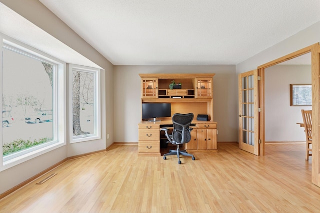 home office with visible vents, baseboards, and light wood-style floors