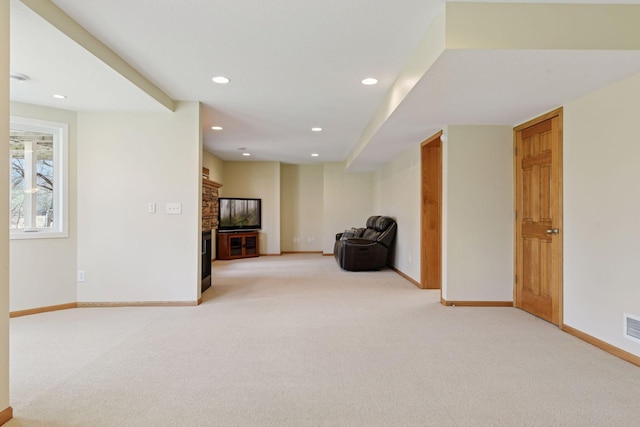 unfurnished room with a fireplace, recessed lighting, light colored carpet, and baseboards