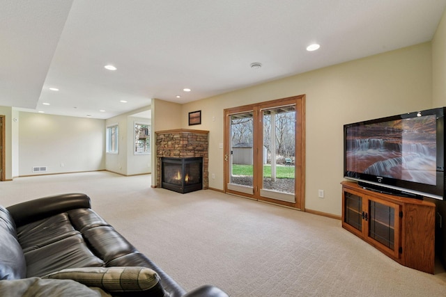 carpeted living room with recessed lighting, visible vents, a stone fireplace, and baseboards