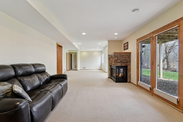 living area with light colored carpet, recessed lighting, a stone fireplace, and baseboards